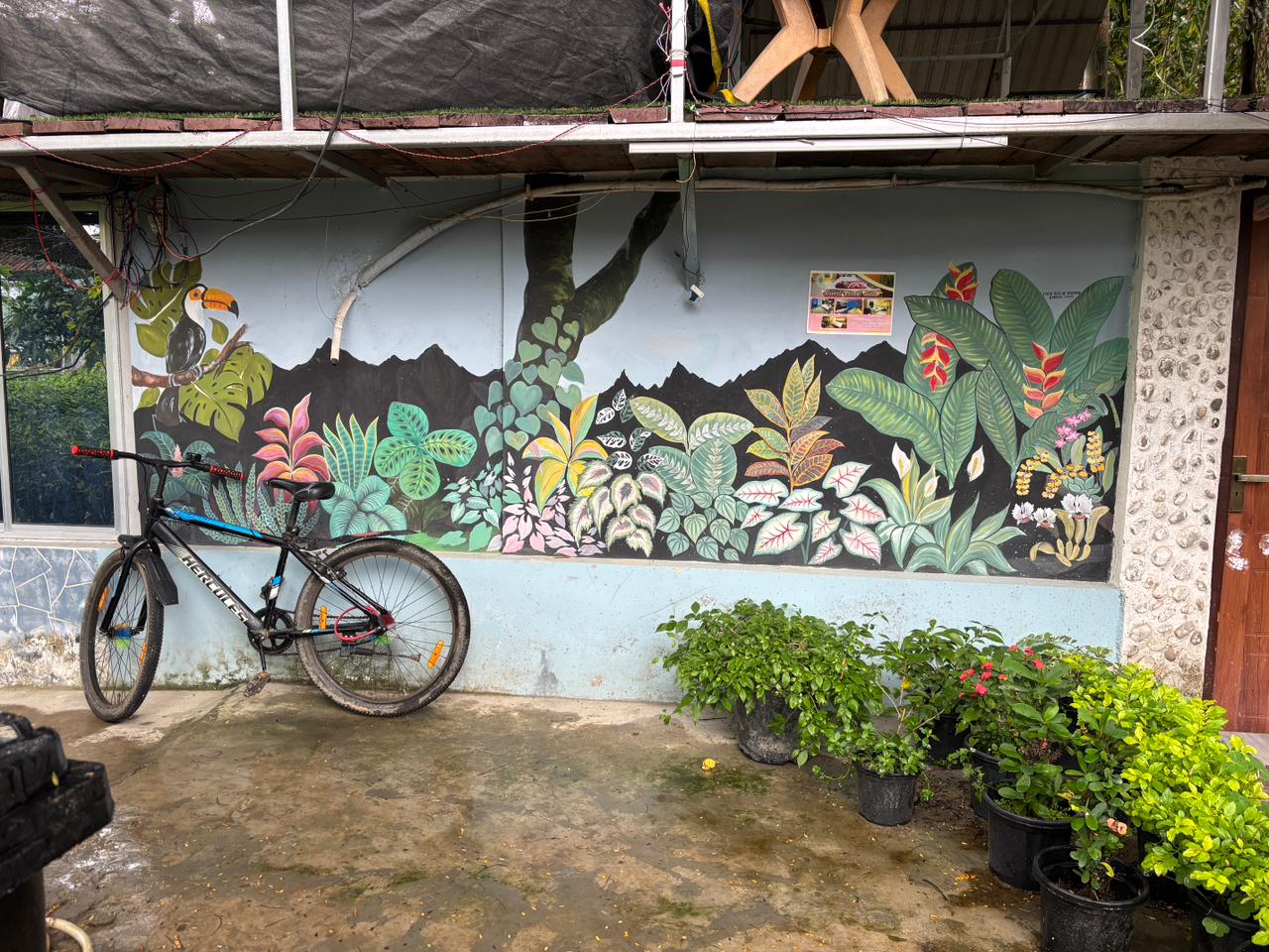 Painted garden mural beside potted plants