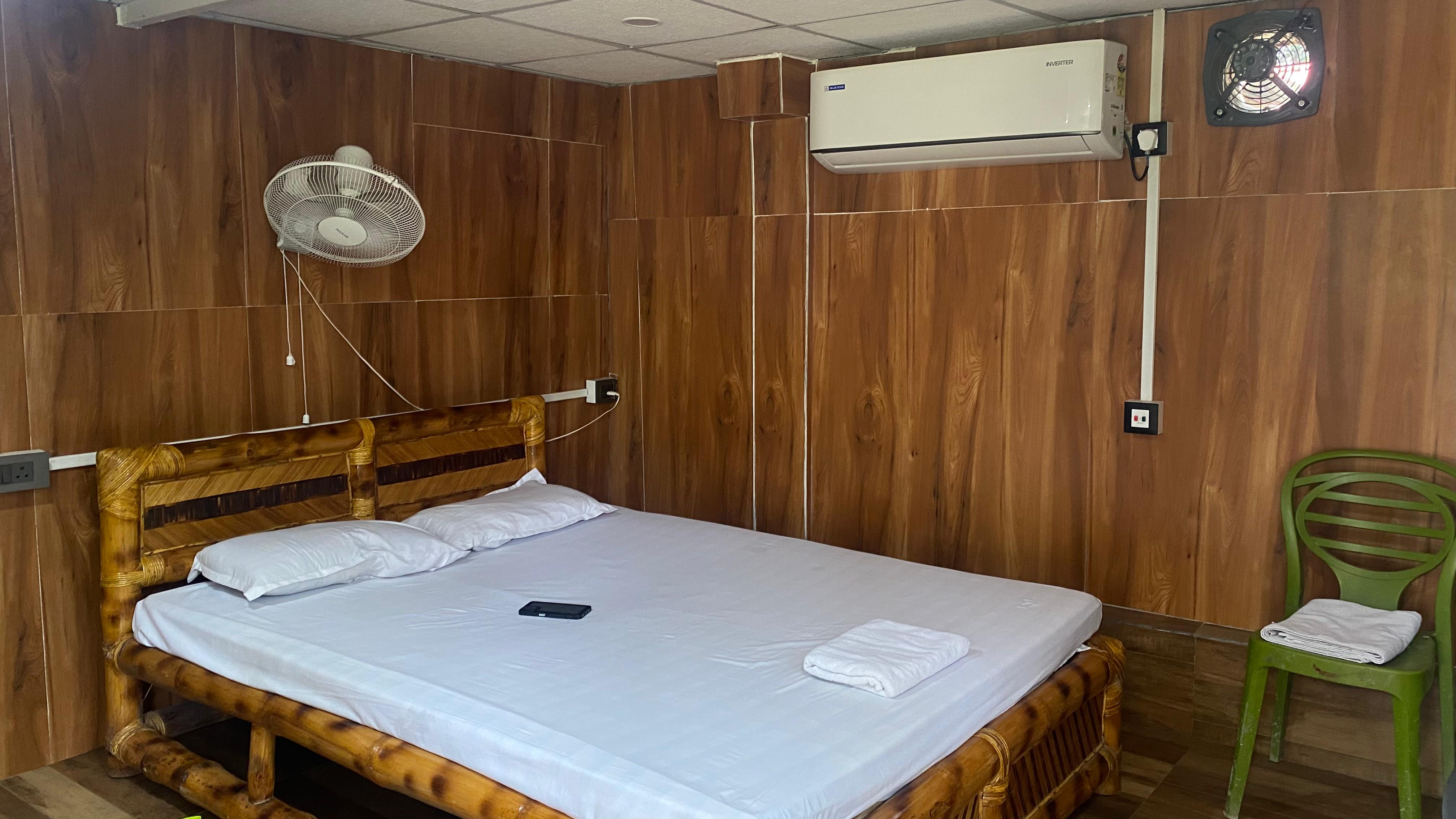 Wood-panel room with bamboo bed and air conditioning